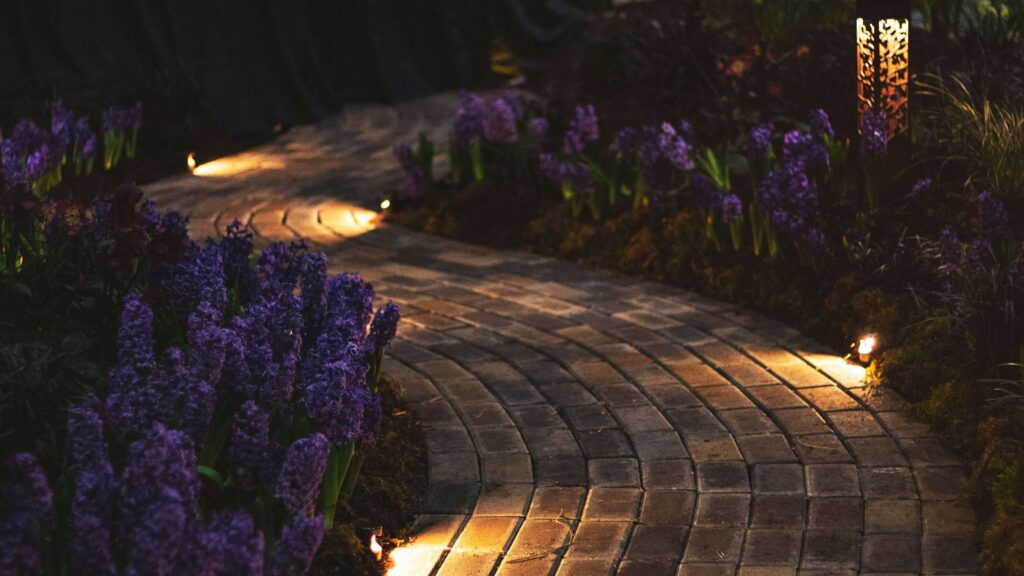 French garden pathway illuminated at night illustrating outdoor lighting and landscape design principles