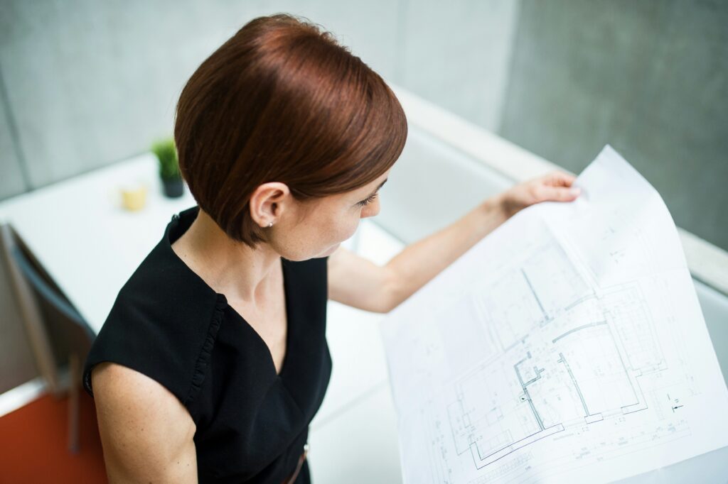 Woman working on an interior layout and space planning project, organizing a floor plan using professional interior design logic.